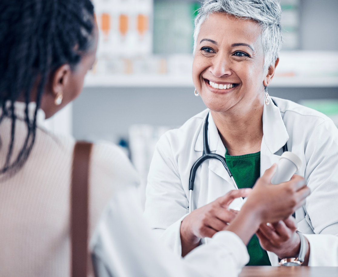 A pharmacist handing a Pillumina aluminum pill bottle to a patient